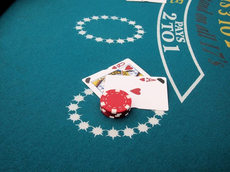 Online Blackjack. Play like a pro with strategies. Image shows Blackjack table, tow cards and betting chips.